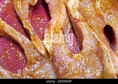 steaks dans un plat de marinade aux herbes près d'une cuisine. Banque D'Images