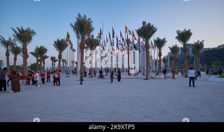 Vue de la corniche de Doha au coucher du soleil montrant les drapeaux des pays participants avec des gens qui célèbrent. Préparation du Qatar pour la coupe du monde de la FIFA 2022 Banque D'Images