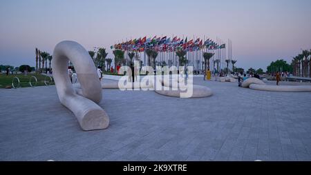 Vue de la corniche de Doha au coucher du soleil montrant les drapeaux des pays participants avec des gens qui célèbrent. Préparation du Qatar pour la coupe du monde de la FIFA 2022 Banque D'Images