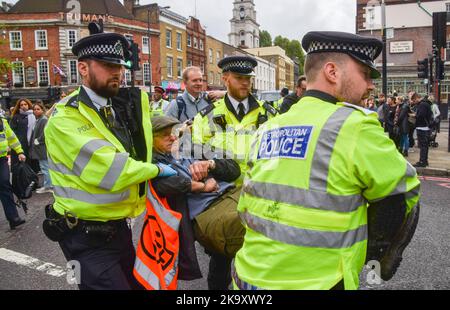 Londres, Angleterre, Royaume-Uni. 30th octobre 2022. Les policiers arrêtent un manifestant alors que les activistes du secteur pétrolier de Just Stop ont bloqué les rues à côté du marché de Spitalfields alors qu'ils poursuivent leurs manifestations exigeant que le gouvernement cesse d'émettre de nouvelles licences de combustibles fossiles. (Image de crédit : © Vuk Valcic/ZUMA Press Wire) Banque D'Images