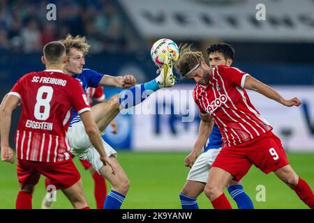 Gelsenkirchen, Allemagne. 30th octobre 2022. Football: Bundesliga, FC Schalke 04 - SC Freiburg, Matchday 12, Veltins Arena: Alex Kral de Schalke (2nd de gauche) et Lucas Höler de Fribourg se battent pour le ballon. Crédit : David Inderlied/dpa - REMARQUE IMPORTANTE : Conformément aux exigences de la DFL Deutsche Fußball Liga et de la DFB Deutscher Fußball-Bund, il est interdit d'utiliser ou d'avoir utilisé des photos prises dans le stade et/ou du match sous forme de séquences et/ou de séries de photos de type vidéo./dpa/Alay Live News Banque D'Images