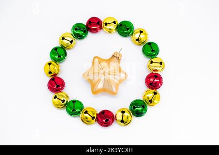 Sonnettes de Noël colorées en or, rouge et vert. En forme de cercle avec étoile dorée décoration de noël au milieu. Le concept du Christ Banque D'Images