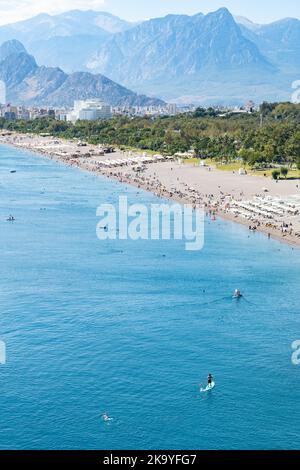 Vue imprenable sur la plage de Konyaalti avec de l'eau claire bleue et des montagnes brumeuses en arrière-plan, Antalya Banque D'Images