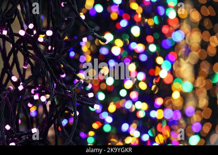 Guirlande lumineuse de Noël dans une boutique. Décorations du nouvel an avec différentes couleurs, mise au point sélective Banque D'Images