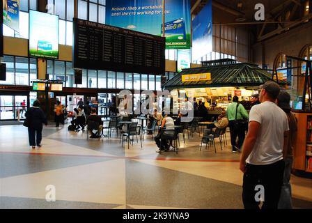 Les gens regardent l'horaire des trains à South Station à Boston, en attendant des informations sur leur trajet ferroviaire et les trajets quotidiens Banque D'Images