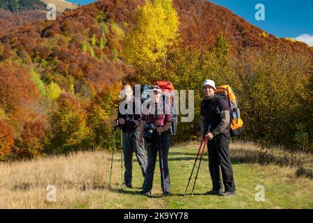 Groupe de randonneurs sur le sentier d'automne pittoresque dans les montagnes. Banque D'Images