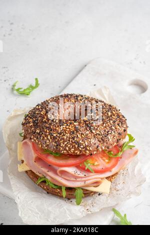 bagel rempli de jambon, fromage à la crème et tomate Banque D'Images