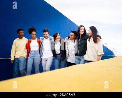 Groupe de jeunes amis multiethniques marchant dans la ville en riant les uns les autres. Amitié et diversité Banque D'Images