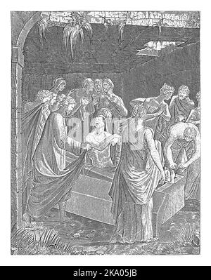 Christ se tient sur le tombeau ouvert de Lazarus et le lève des morts. Hommes et femmes, l'un d'eux couvrant son nez, montre. Banque D'Images