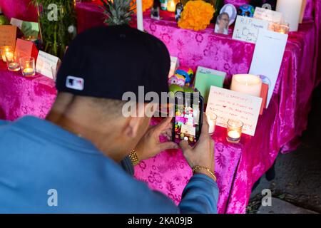 New York, NY, États-Unis. 30th octobre 2022. Mano a Mano: Culture mexicaine sans frontières (Cultura Mexicana Sin Fronteras) a organisé une célébration Dia de Muertos à l'église Saint-Marc In-the-Bowery, avec un autel commémoratif d'offrandes, de photographies et de souvenirs écrits, ainsi que de la nourriture, de l'artisanat et des divertissements mexicains. Un homme photographie la carte commémorative qu'il a placée. Credit: Ed Lefkowicz/Alay Live News Banque D'Images