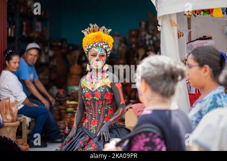 Morelia, Mexique, 30 octobre 2022, les festivités du jour des morts à Michoacan incluent le festival de Catrina à Capula, un village artisanal où ce modèle vivant interagit avec les gens qui passent. Les squelettes ou crânes élégamment habillés connus sous le nom de catrinas sont devenus populaires pendant la Révolution mexicaine au début des années 1900 comme une satire de la classe supérieure moralement décadente. Brian Overcast/Alamy Live News Banque D'Images