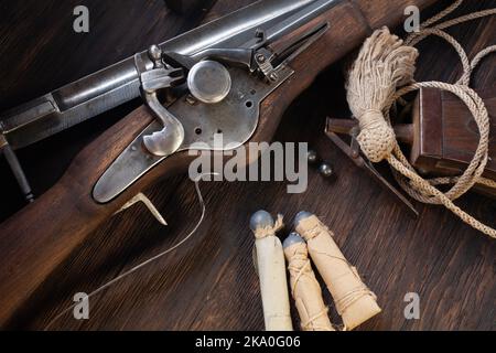 ancienne mousquet de flintlock du xviie siècle avec ballon de poudre et balles led sur terrasse en bois. Banque D'Images