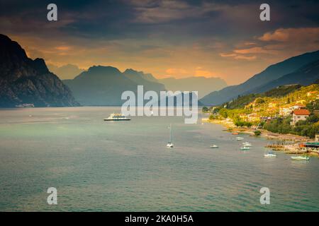 Au-dessus du lac de Garde idyllique avec des voiliers à Malcesine au coucher du soleil, alpes italiennes Banque D'Images