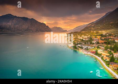 Au-dessus du lac de Garde idyllique avec des voiliers à Malcesine au coucher du soleil, alpes italiennes Banque D'Images