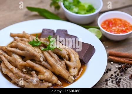 Nourriture thaïlandaise, soupe de pieds de poulet mijotée, cuisson de pieds de poulet ragoût sur blanc avec des herbes et des ingrédients d'épices avec des légumes de citron Chili sur b bois Banque D'Images