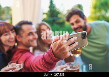 Des amis heureux à la fête en terrasse emportant le selfie avec leur smartphone s'amuser ensemble - les jeunes de la génération du millénaire prennent des souvenirs à l'extérieur dans le terr Banque D'Images