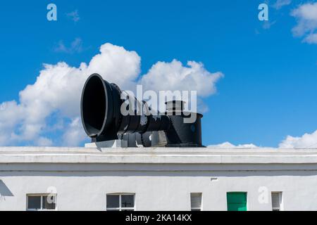 Une vue rapprochée d'un grand foghorn en métal noir sur le toit d'un bâtiment de phare Banque D'Images