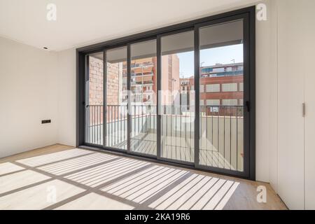 Ombres sur le sol de la lumière du soleil par de grandes fenêtres. Cette nouvelle chambre dispose de parquet dans un appartement rénové. Banque D'Images