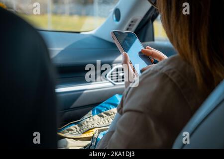 femme passager assis en voiture à l'aide du téléphone Banque D'Images