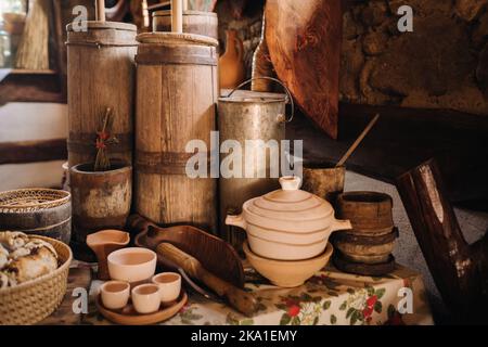 Vieux fûts en bois et plats sur la table dans le village. Vaisselle antique rustique Banque D'Images