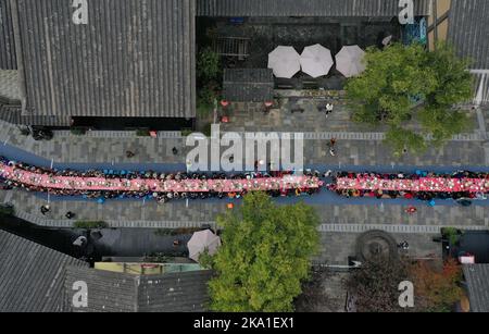 QIANDONGNAN, CHINE - 31 OCTOBRE 2022 - des photos aériennes montrent les personnes qui profitent d'un long banquet à Wanda Town pittoresque à Qiandongnan Miao et Dong Banque D'Images