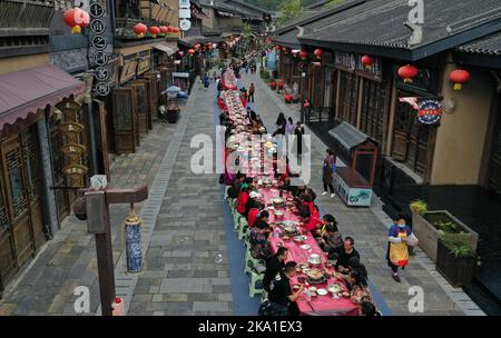 QIANDONGNAN, CHINE - 31 OCTOBRE 2022 - des photos aériennes montrent les personnes qui profitent d'un long banquet à Wanda Town pittoresque à Qiandongnan Miao et Dong Banque D'Images