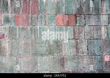 Texture du mur avec des blocs de pierre de couleurs rouge, verte et grise. Arrière-plan horizontal avec texture décorative en pierre Banque D'Images