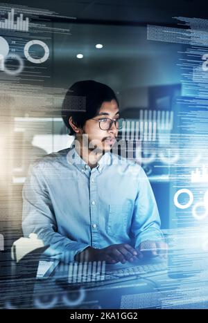 Quand il s'agit de codes, il s'agit de l'homme à appeler. Un jeune programmeur concentré travaillant sur son ordinateur dans le bureau pendant la nuit. Banque D'Images