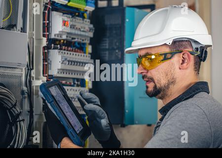 Man, un technicien en électricité travaillant dans un tableau de commutation avec des fusibles. Banque D'Images