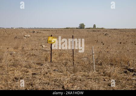 Panneau d'avertissement du champ de mines en hébreu, anglais et arabe, plateau du Golan, Israël Banque D'Images