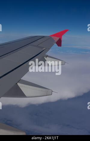 L'aile d'un avion moyen-courrier au-dessus des nuages et avec le ciel bleu. L'atmosphère d'un voyage. Banque D'Images