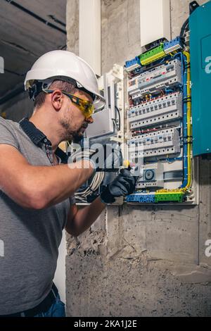 Man, un technicien en électricité travaillant dans un tableau de commutation avec des fusibles. Banque D'Images