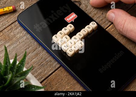 La peur de manquer (fomo) concept: Smartphone sur une table en bois avec un peu de mourir composant une phrase. Banque D'Images