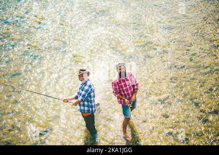Pêcheurs hommes amis et truite trophée. Père et fils de pêche. Générations hommes pêche dans la rivière. Banque D'Images