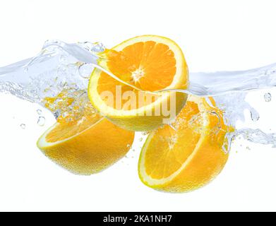 Oranges tombant dans l'eau avec des éclaboussures sur fond blanc Banque D'Images