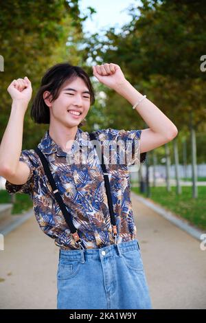 Homme asiatique souriant et dansant rock and roll dans un parc. Banque D'Images