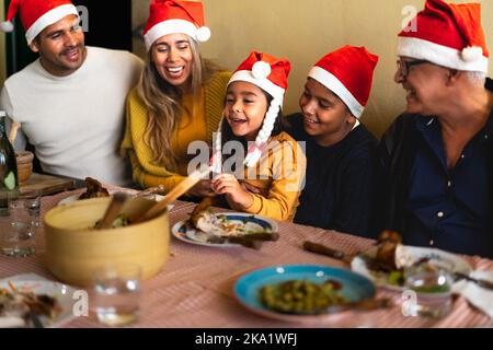 Bonne famille latine appréciant les vacances de Noël avoir un dîner ensemble à la maison Banque D'Images