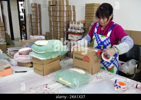 NANTONG, CHINE - le 31 OCTOBRE 2022 - un employé de Nantong Bolia Rain Gear Manufacturing Company trie et arrange des marchandises dans un parc logistique de Nanto Banque D'Images