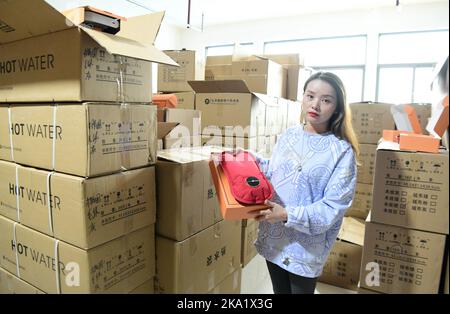 NANTONG, CHINE - le 31 OCTOBRE 2022 - un employé de Nantong Bolia Rain Gear Manufacturing Company dans le parc logistique vend une bouteille d'eau chaude électrique Banque D'Images