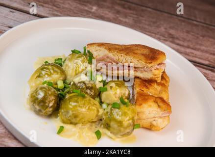 Recette pour des filets de poulet faits maison de style cordon bleu avec choux de Bruxelles Banque D'Images