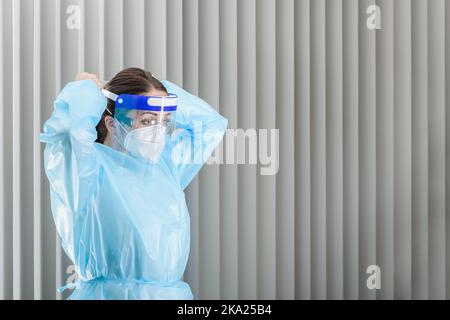 Médecin mettant l'équipement de protection individuelle à l'hôpital avant les visites du patient Banque D'Images