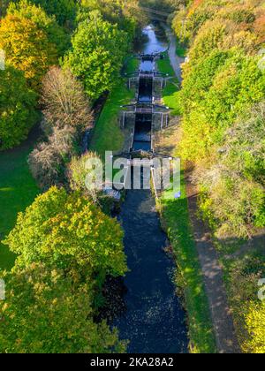 Photo verticale aérienne des écluses de Newlay sur le canal de Leeds et de Liverpool, le jour de l'automne. Newlay Locks est un escalier à trois étages. Banque D'Images