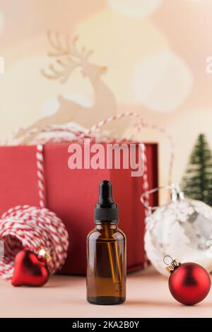 Sérum hydratant dans un flacon sur fond de nouvel an. Cadeau de Noël pour les produits cosmétiques Banque D'Images