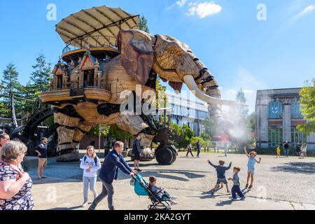 La marionnette géante du Grand Eléphant, qui fait partie des machines de l'attraction touristique de l'île de Nantes, pulvérise de l'eau avec son tronc sur les enfants excités. Banque D'Images