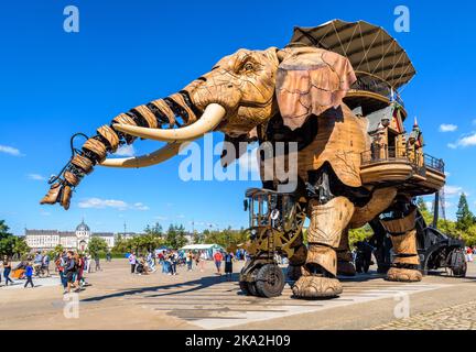 La marionnette géante animée du grand éléphant, qui fait partie des machines de l'attraction touristique de l'île de Nantes, se promène lentement au milieu des spectateurs par une journée ensoleillée. Banque D'Images