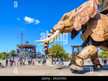 La marionnette géante du Grand Eléphant, qui fait partie des machines de l'attraction de l'île de Nantes, avec le carrousel des mondes marins au loin. Banque D'Images