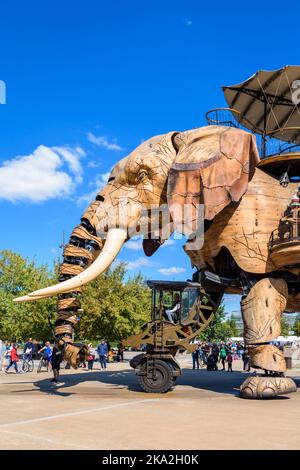 La marionnette géante animée du grand éléphant, qui fait partie des machines de l'attraction touristique de l'île de Nantes, se promène lentement au milieu des spectateurs par une journée ensoleillée. Banque D'Images