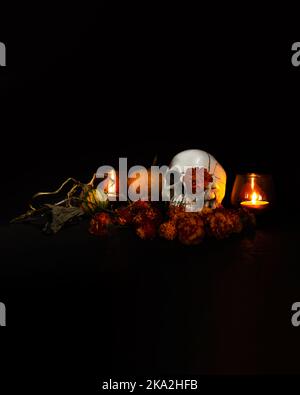 Crâne, bougies allumées et fleurs marigolées sur fond noir. Concept de Dia de los muertos jour ou jour des morts. Bannière Halloween sombre. Banque D'Images