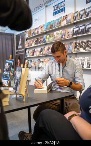 Cracovie, Pologne - 28-30 octobre 2022: Bartłomiej Kowaliński, écrivain polonais signe des livres pendant la foire du livre de Cracovie en 2022 à l'exposition internationale et Banque D'Images