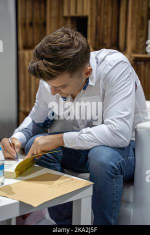 Cracovie, Pologne - 28-30 octobre 2022: Jakub Małecki, écrivain polonais signe des livres pendant la Foire du livre de Cracovie en 2022 à l'exposition internationale et le couvent Banque D'Images